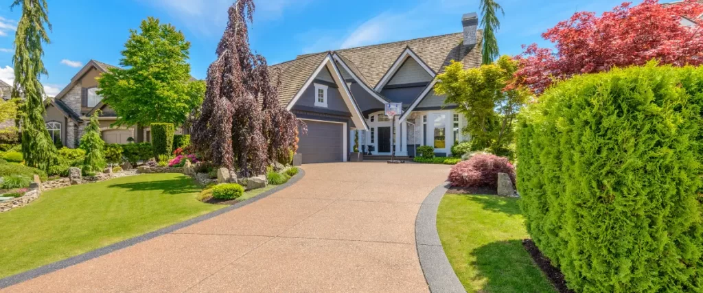 Wide decorative driveway leading to a suburban home with landscaped yard.