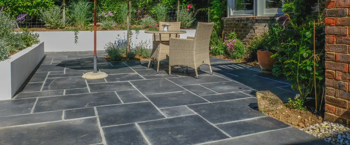 A beautifully crafted circular stone patio surrounded by lush garden landscaping.
