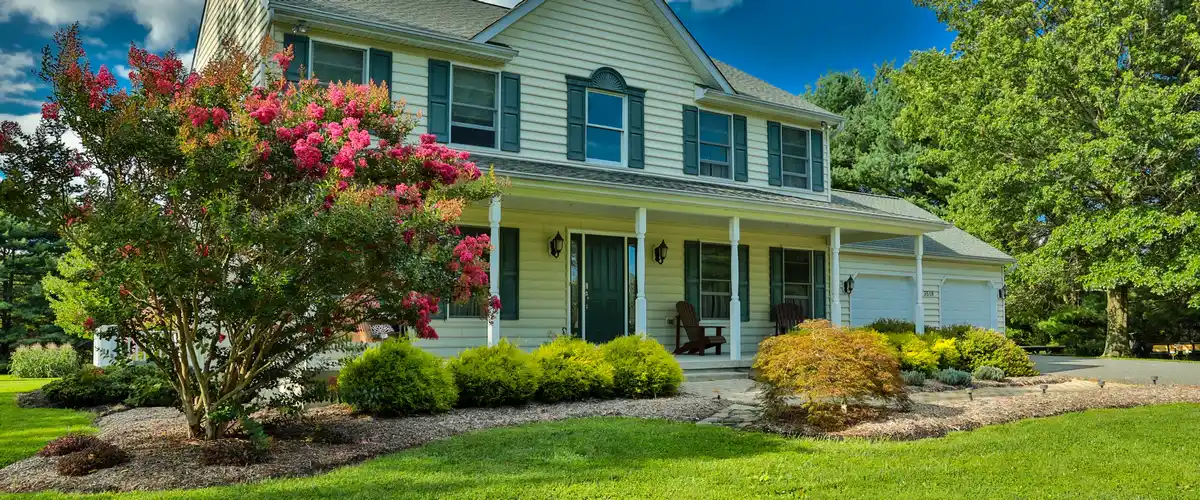 A beautifully manicured residential landscape featuring sustainable plants and stone pathways.