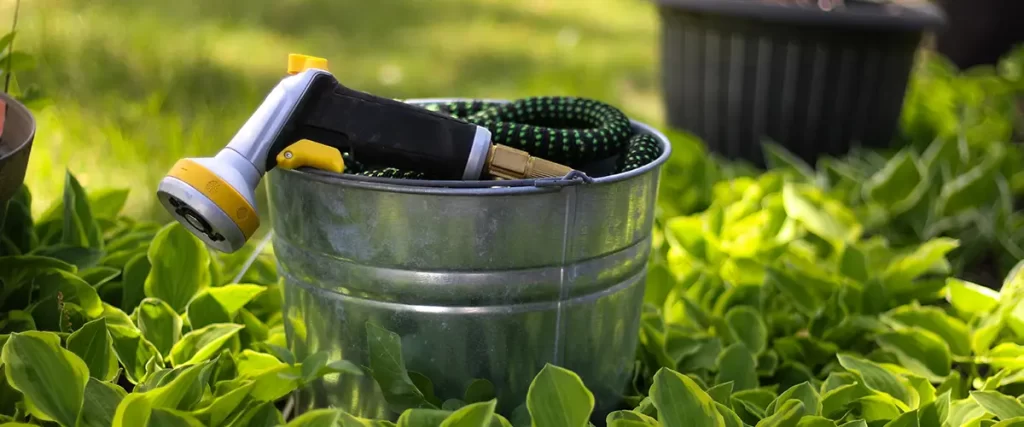 Garden hose and spray nozzle ready for landscape watering and lawn maintenance